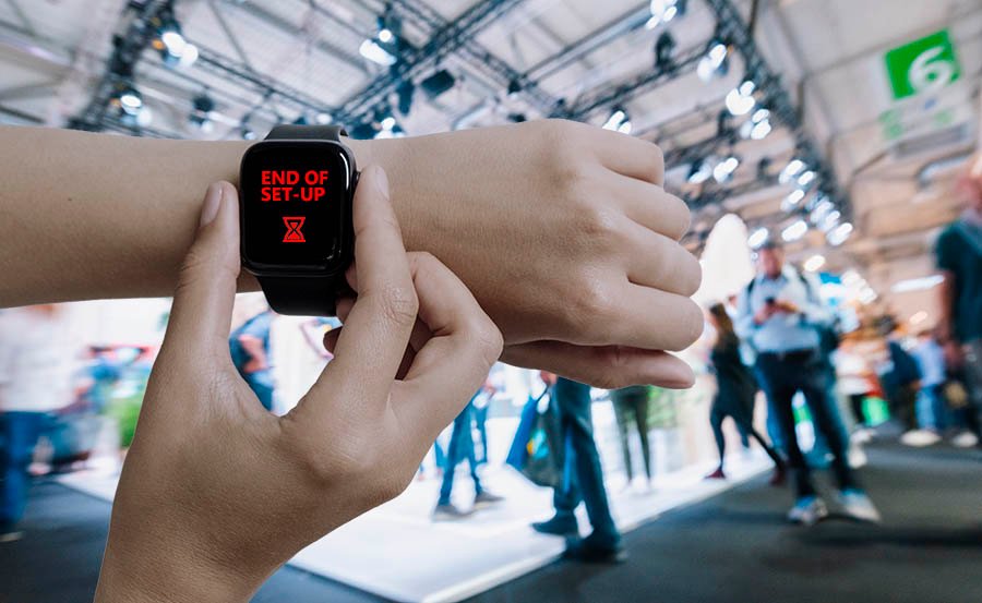 main avec une smartwatch avec un stand d'exposition en arrière-plan