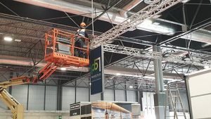 gennie crane installing truss at trade show
